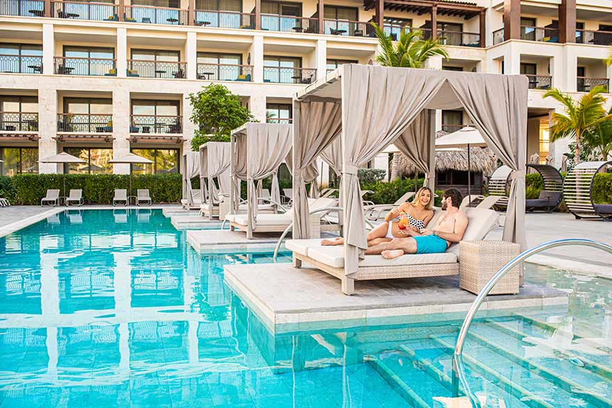 Couple sirotant un cocktail dans la piscine