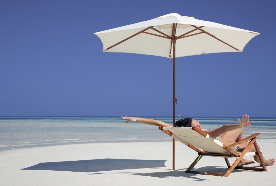 Woman enjoying lying in a hammock on the seashore.