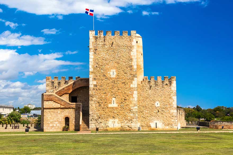 Ozama Fortress seen from afar, with a Dominican Republic flag waving