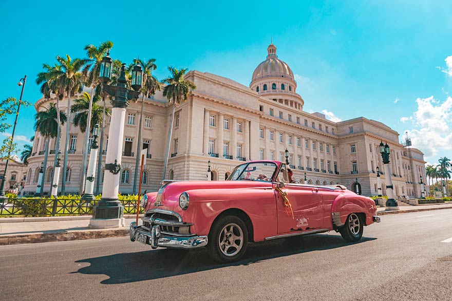 Rosafarbenes Auto, das durch Havanna in Kuba fährt.